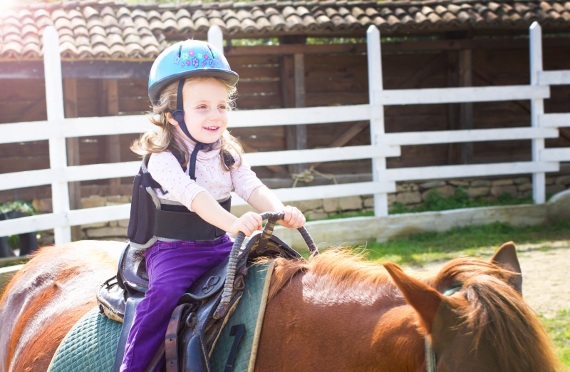 little girl on horseback as hippotherapy